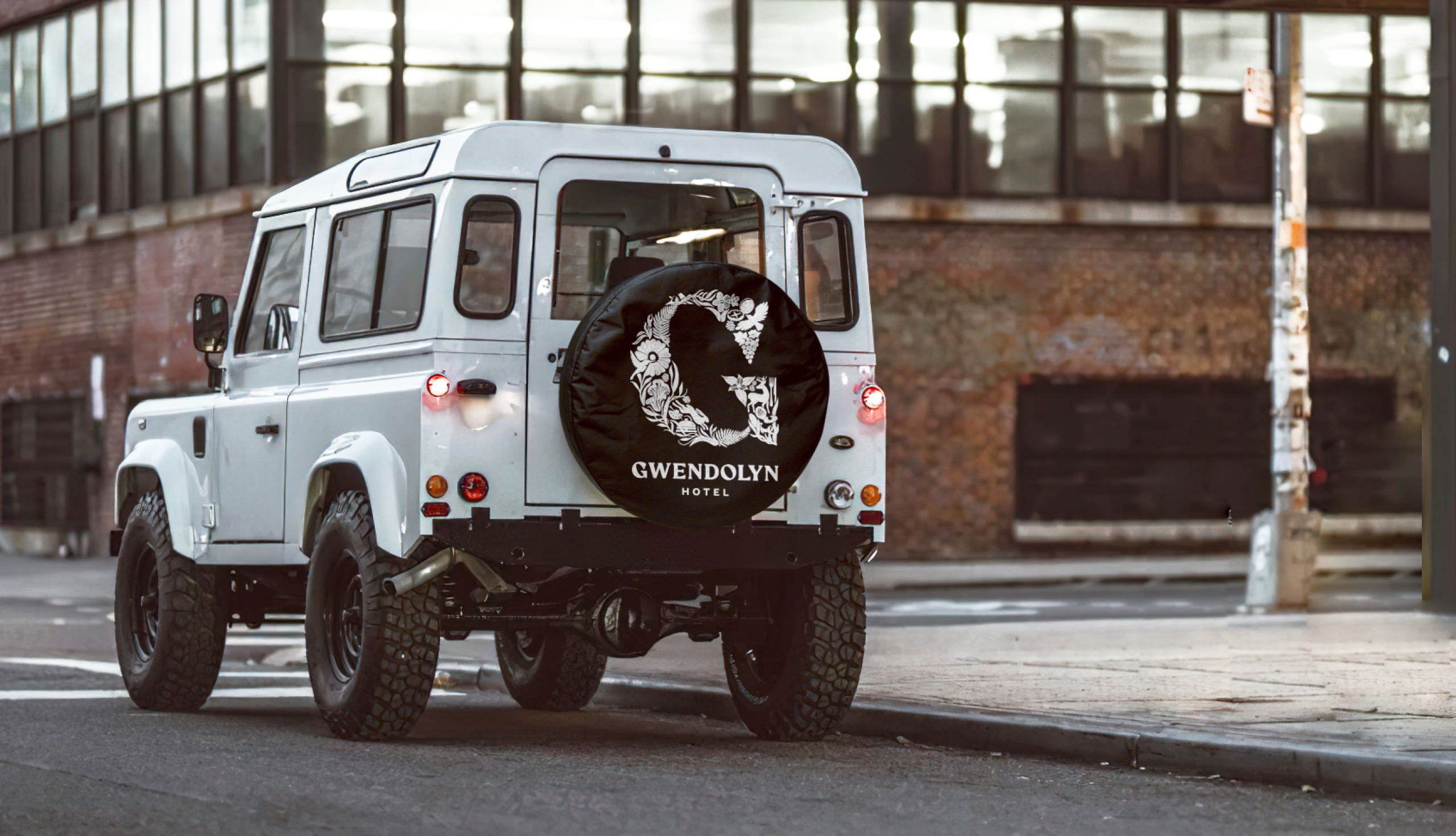 White Land Rover truck with Gwendolyn logo on spare tire cover
